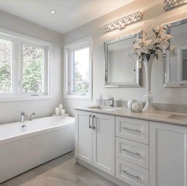 Bright, modern bathroom with bathtub, dual sinks, and floral decor.
