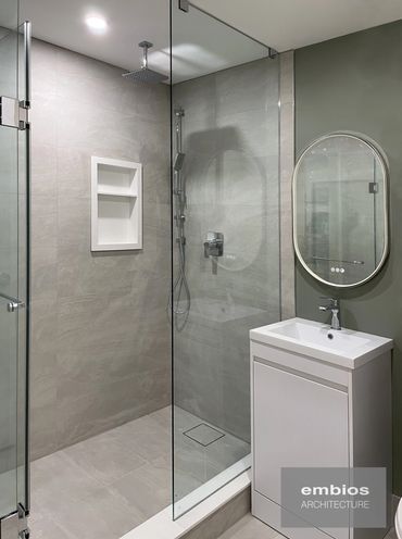 Modern bathroom with glass shower and minimalist sink.