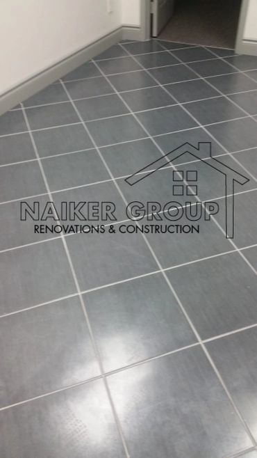 Newly installed dark gray tiled floor in a hallway corner.