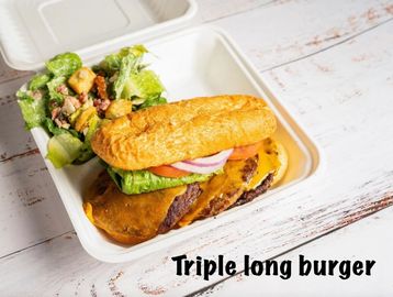 Triple long burger with fresh side salad in a takeout container.