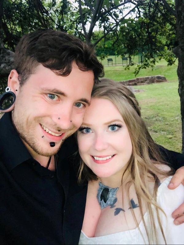 Selfie of Pete and his wife on their wedding day under a tree smiling at camera