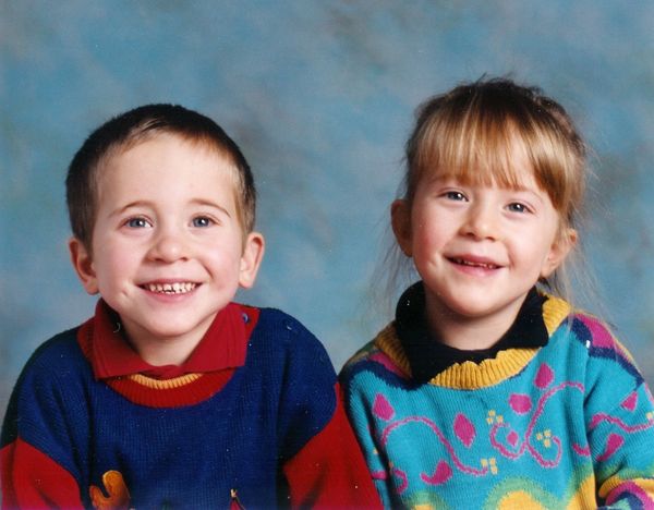 Pete and twin sister when children, wearing very colourful jumpers and smiling