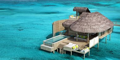 Overwater bungalow with thatched roof and private pool in clear turquoise sea.