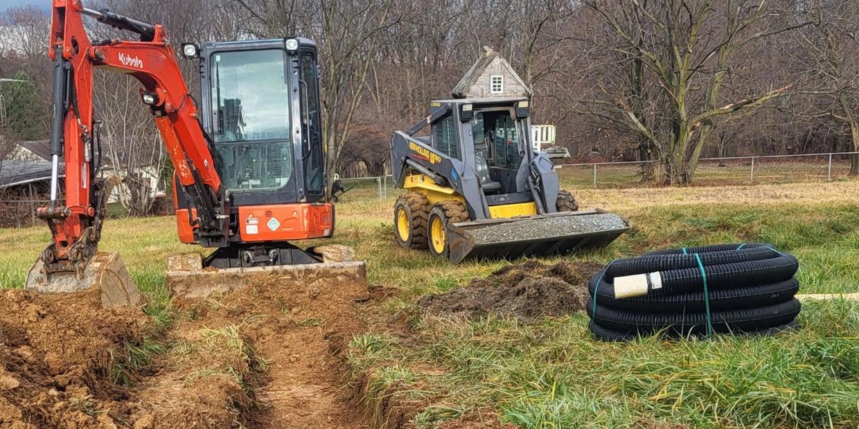 mini excavator and skid loader used for trenching in new utility lines