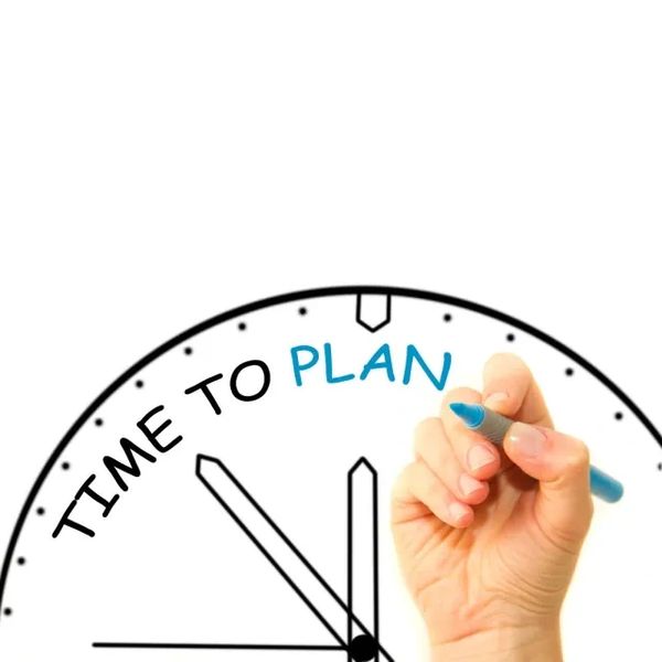 Hand writing 'Time to plan' on a clock face.
