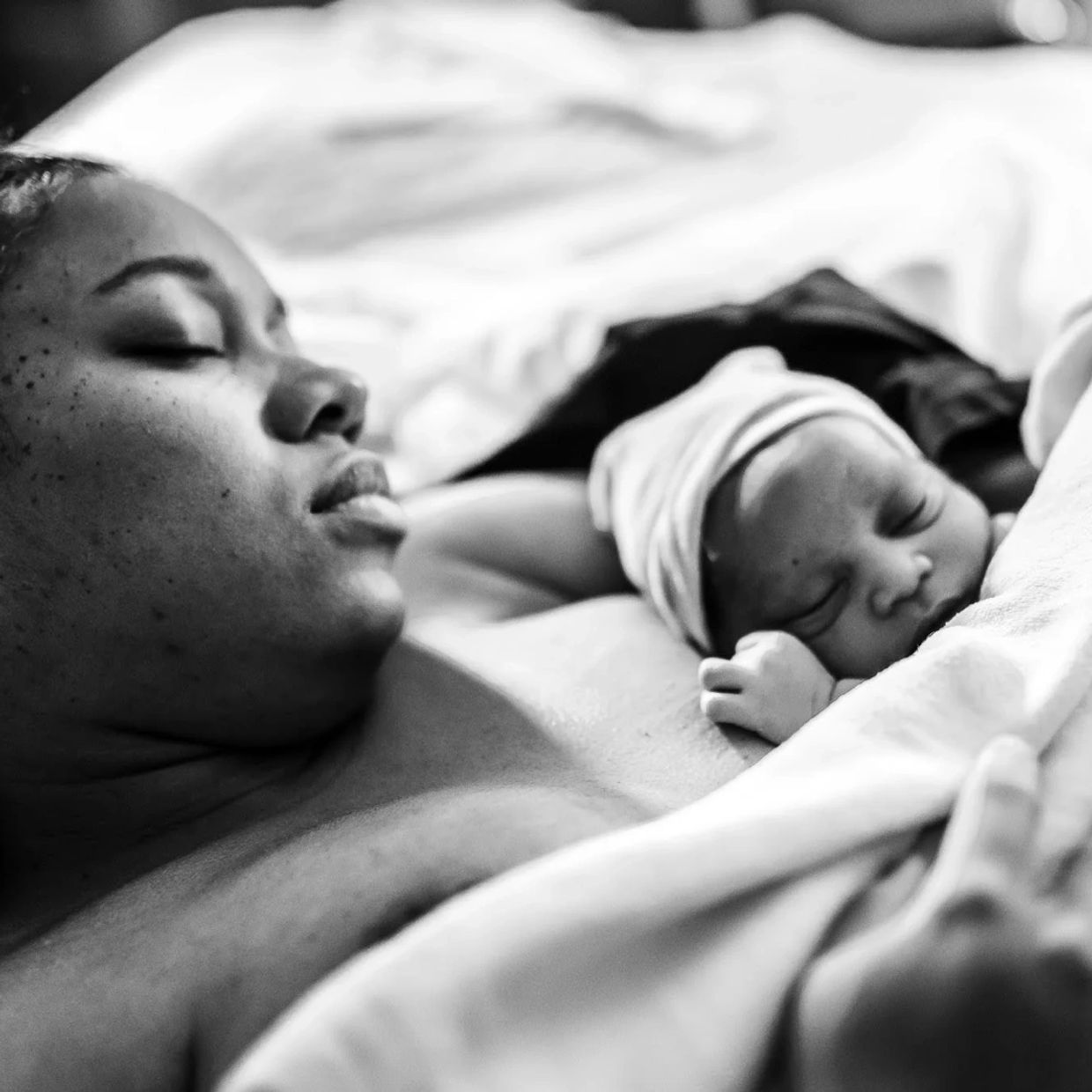 A mother and newborn baby peacefully resting together.