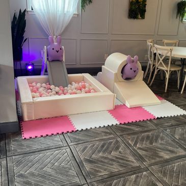 Indoor kids' play area with bunny-themed slides and a ball pit.