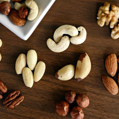 Various nuts arranged on a wooden surface.