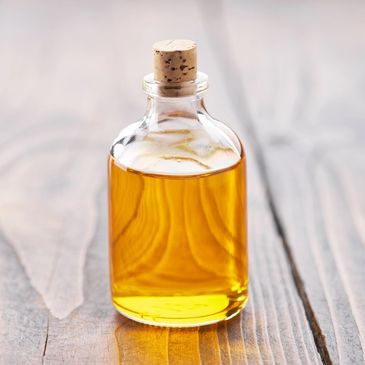 Small glass bottle filled with golden liquid and sealed with a cork.