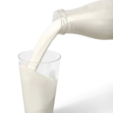 Milk being poured from a bottle into a glass.