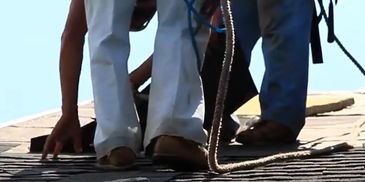 Amish Roofer legs nailing down a shingle