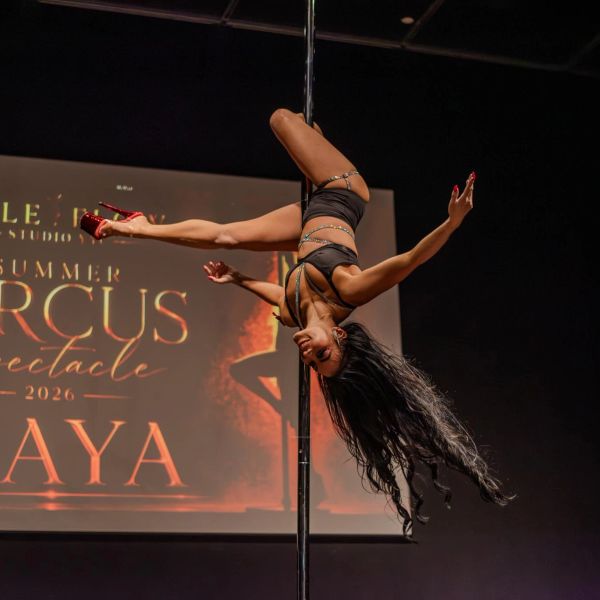 Woman performing an impressive pole dance move.