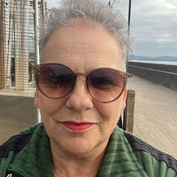 Woman wearing sunglasses outdoors near a waterfront.
