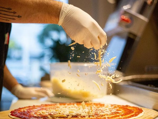 pizza delgada con salsa de tomate artesanal en preparación