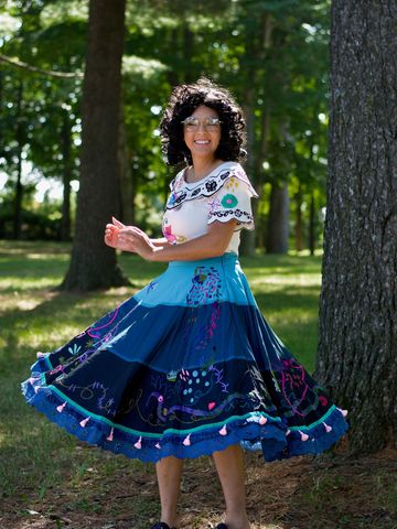 Personnage enchanteur en robe bleue tourbillonnante lors d’une fête extérieure.