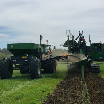 Rear image of gravel cart filling working trencher.