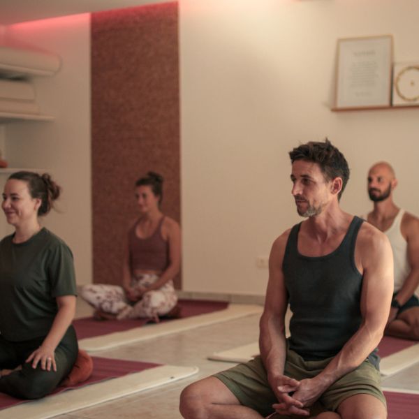 People meditating in a calm yoga studio.