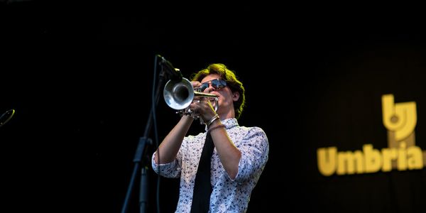 Musician playing trumpet on stage at Umbria Jazz Festival.