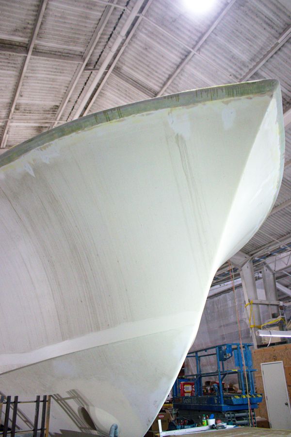 Close-up of a boat hull inside a workshop under construction.