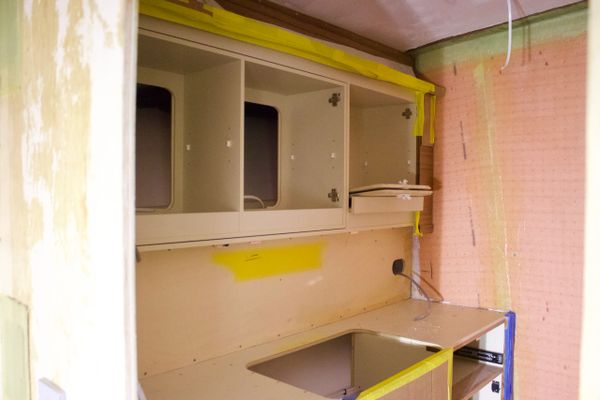 Partially installed kitchen cabinets and countertop in progress.