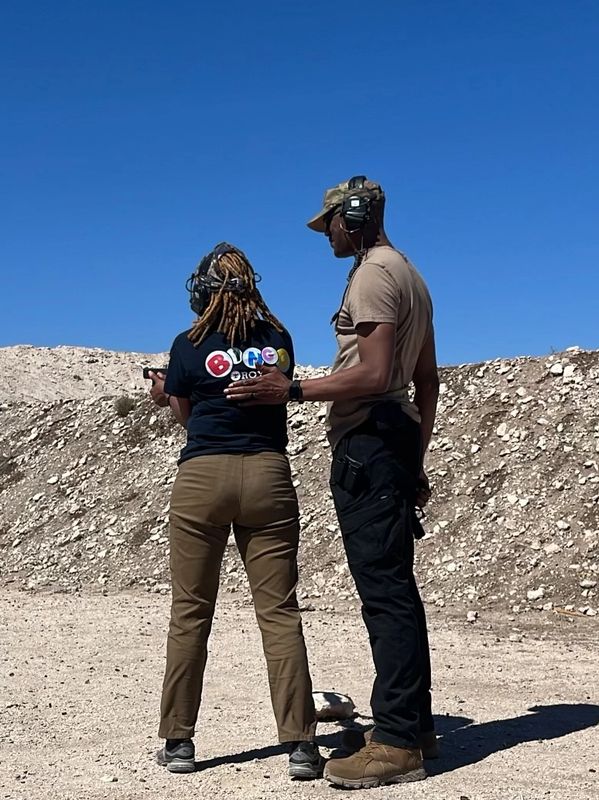 A man teaches a woman to gun shoot