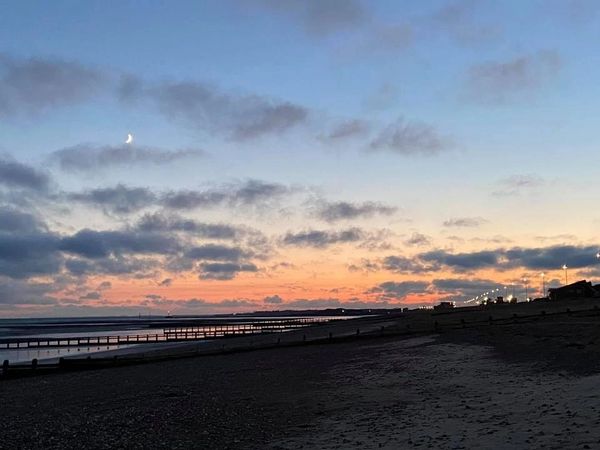Image shows sunset and moon rise over Littlehampton beach.