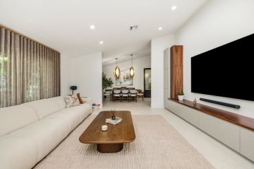 Modern living room with beige sofa and wooden coffee table.