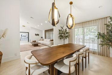 Modern dining room with wooden table and elegant chairs.