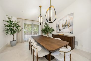 Modern dining room with wood table and pendant lights.