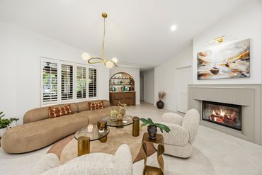 Modern living room with curved sofa and fireplace.