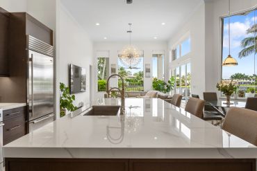 Modern kitchen with a large island and elegant lighting.