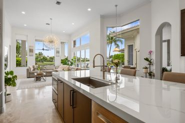 Modern open kitchen and living area with large windows.
