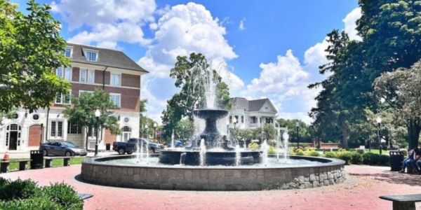 Stone water fountain in a sunny town square.