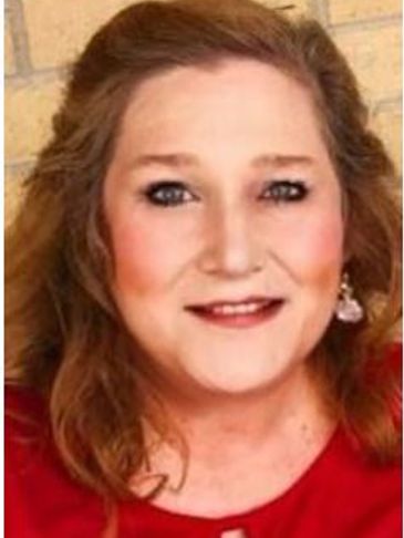 Smiling woman with light makeup and earrings.