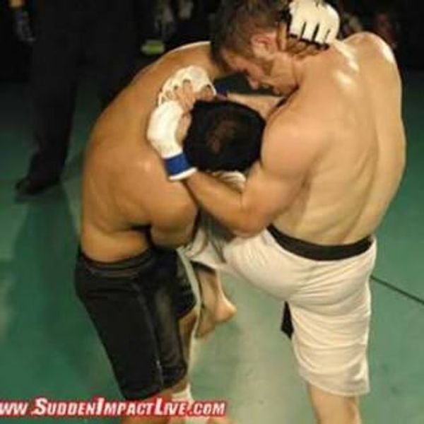 Two fighters grappling in a martial arts match.