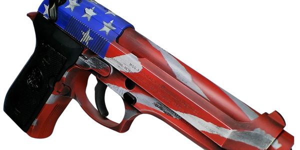 A handgun painted with an American flag design in red, white, and blue.