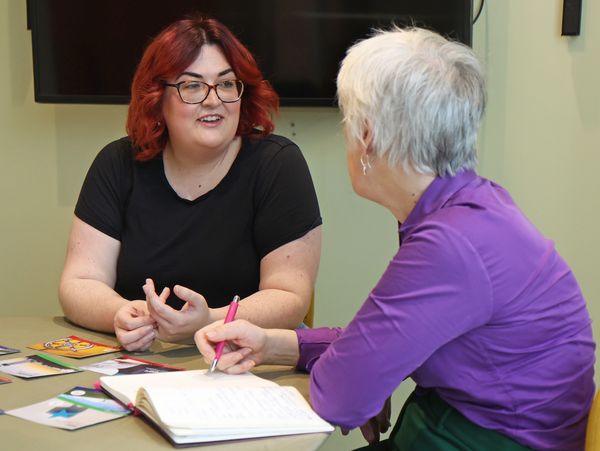 Tash sits with a client in purple planning monthly marketing content.