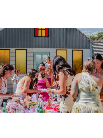 Group of women enjoying an outdoor gathering at a colorful venue.