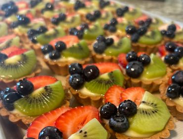 Mini fruit tarts with blueberries, kiwi, and strawberries.