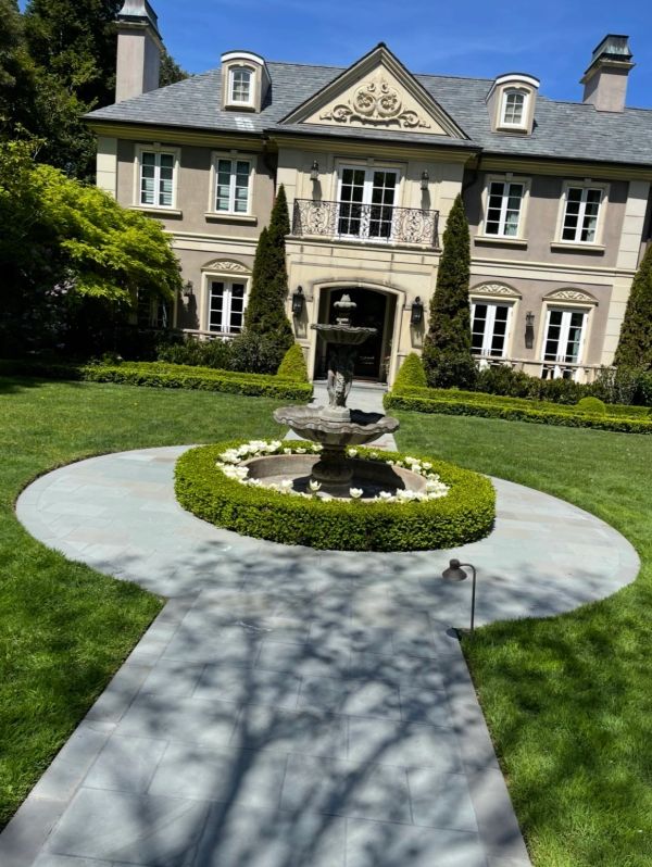 Elegant mansion with a central fountain and manicured garden.