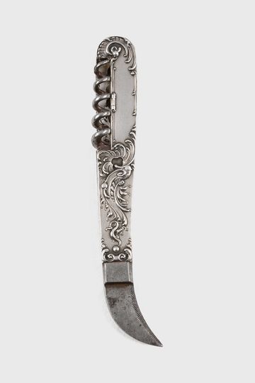 Antique silver knife with ornate floral engravings and a curved blade.