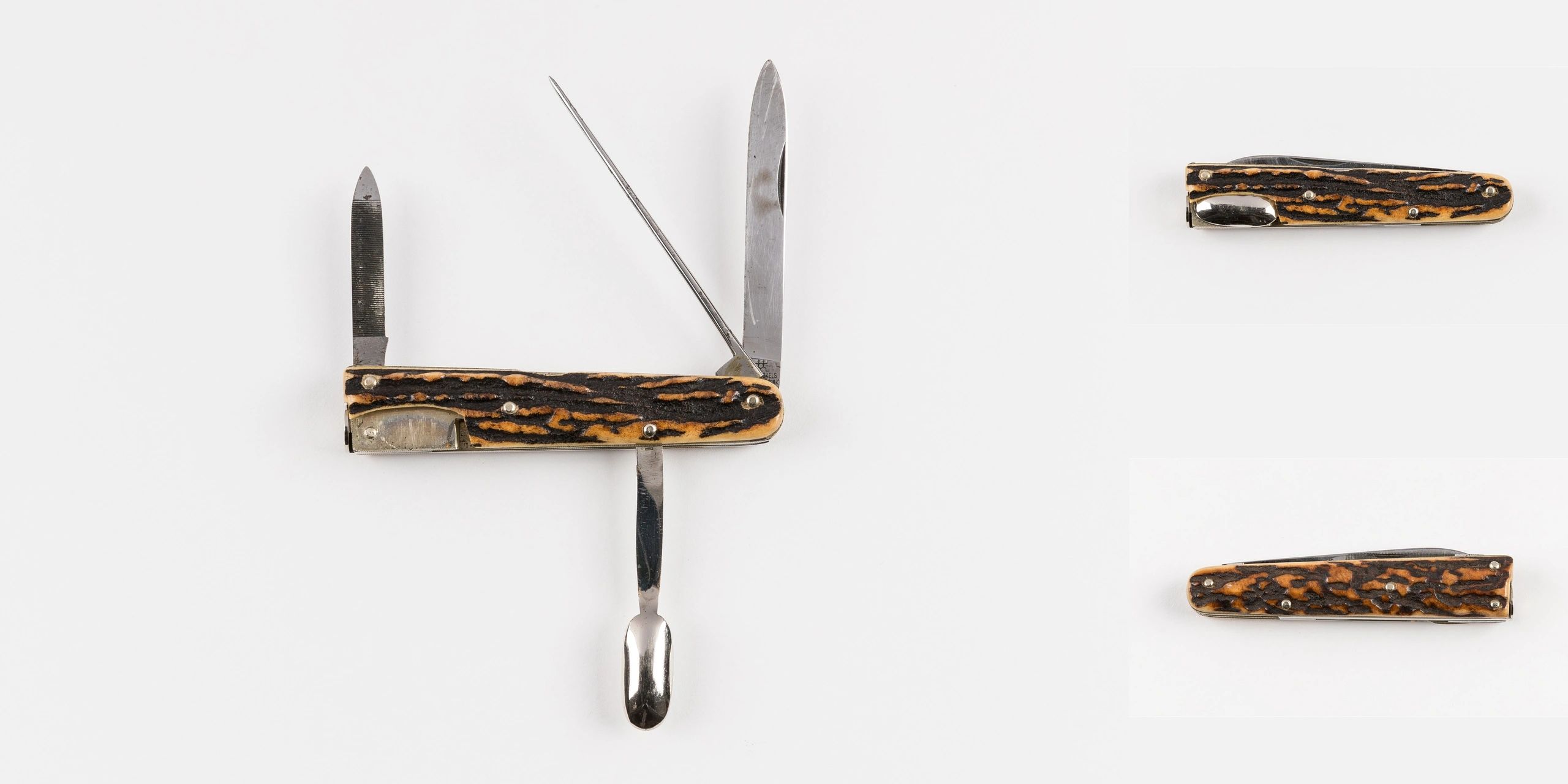 Vintage pocket knife with multiple tools and textured handle.