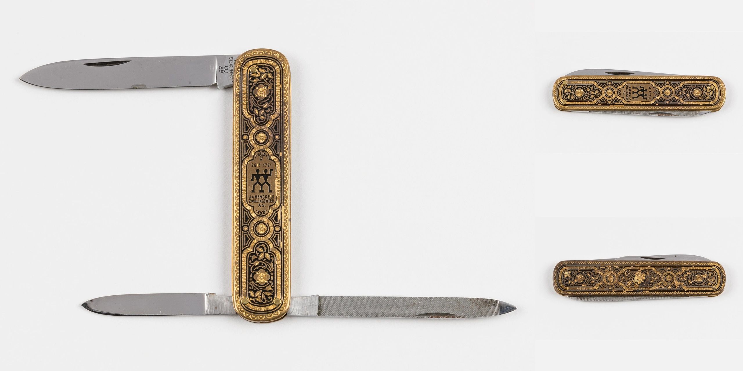 Decorative Zwilling J.A. Henckels pocket knives with intricate gold and black designs.