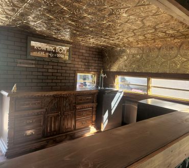 Roaming NoMi Mobile Bar includes gold ceiling, brick, wood accents, and gold framed windows. 