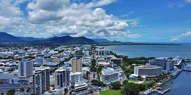 A coastal city with modern buildings under a partly cloudy sky.