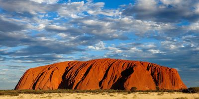 Red rock formation under a partly cloudy sky.