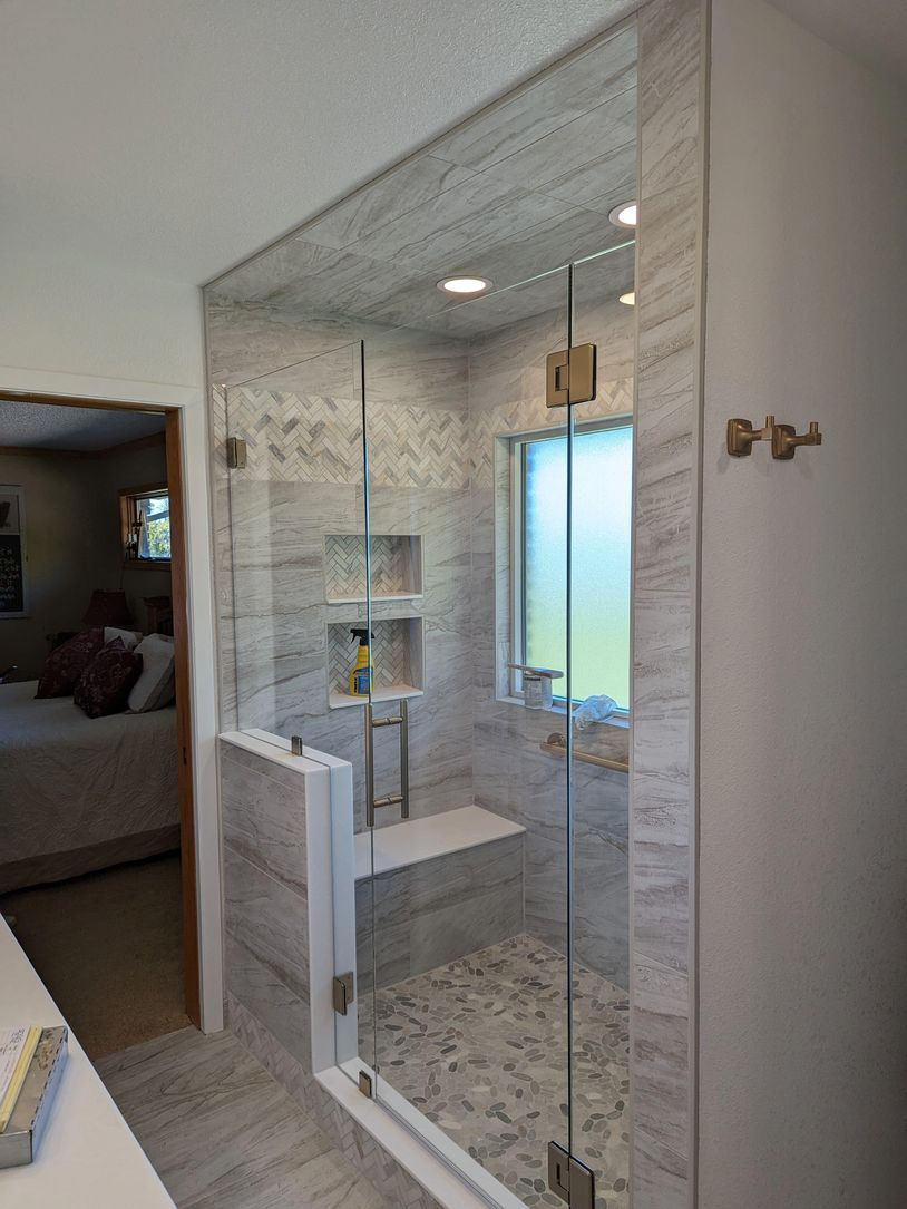 Frameless glass shower door with champagne bronze hardware in walk in shower