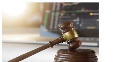 Wooden judge gavel with computer screen background.
