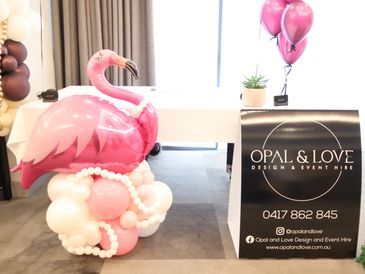 Pink flamingo balloon decoration next to an event hire sign.