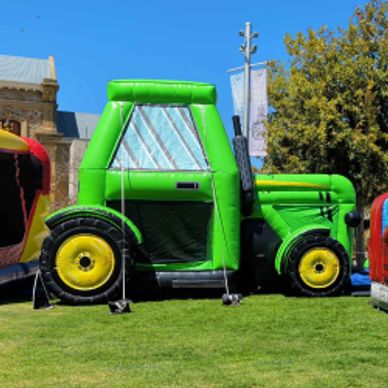 Green inflatable tractor on grass.